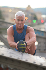 Image showing handsome man stretching before jogging