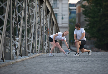 Image showing couple warming up and stretching before jogging