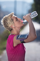 Image showing woman drinking  water after  jogging