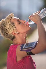 Image showing woman drinking  water after  jogging