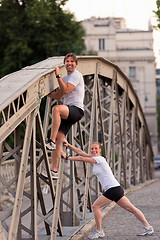 Image showing couple warming up and stretching before jogging