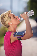 Image showing woman drinking  water after  jogging