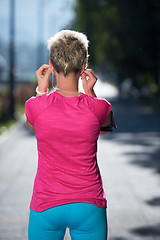 Image showing jogging woman setting phone before jogging