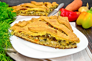 Image showing Pie with cabbage and sorrel in plate on dark board