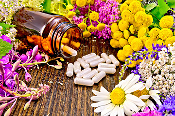 Image showing Capsules in brown jar with flowers on board