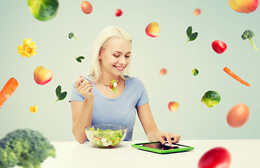Image showing smiling woman eating salad with tablet pc