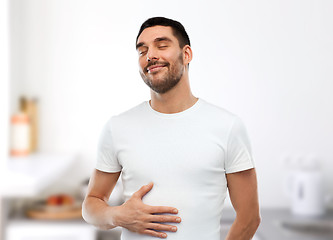 Image showing happy full man touching tummy over kitchen