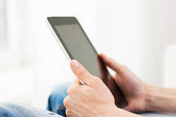 Image showing close up of man working with tablet pc at home