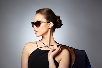 Image showing happy woman in black sunglasses with shopping bags