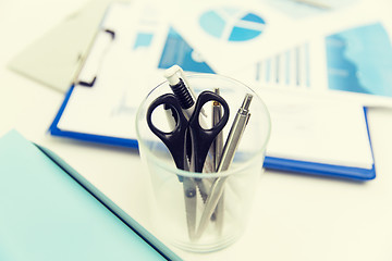 Image showing close up of cup with scissors and pens at office