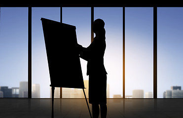 Image showing silhouette of woman with flipboard over office