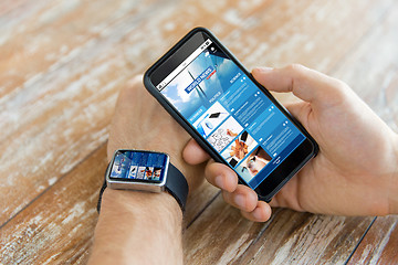 Image showing hands with news web page on smart phone and watch