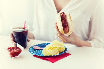 Image showing close up of woman eating hot dog with cola