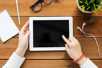 Image showing close up of woman with tablet pc on wooden table