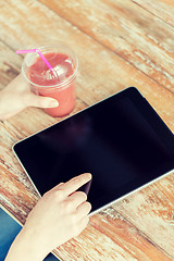 Image showing close up of hands with tablet pc and smoothie