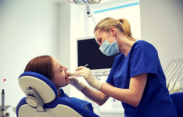 Image showing female dentist checking patient girl teeth