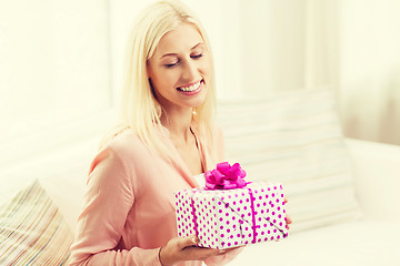 Image showing smiling woman with gift box at home