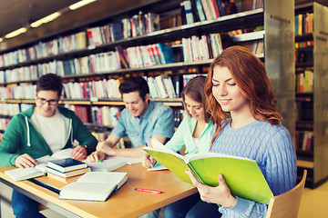 Image showing happy students reading books in library