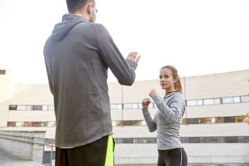 Image showing woman with trainer working out self defense strike