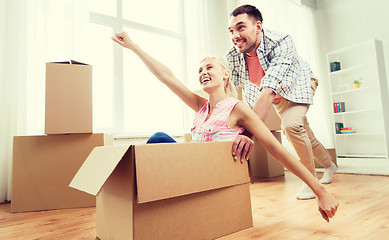 Image showing couple with cardboard boxes having fun at new home