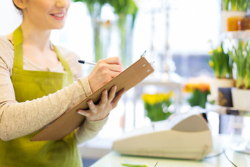 Image showing close up of woman with clipboard at flower shop