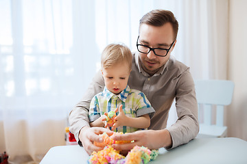 Image showing father and son playing with ball clay at home