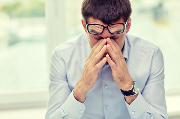 Image showing tired businessman with eyeglasses in office