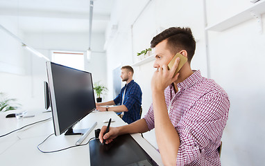 Image showing man with computer and tablet talking on smartphone