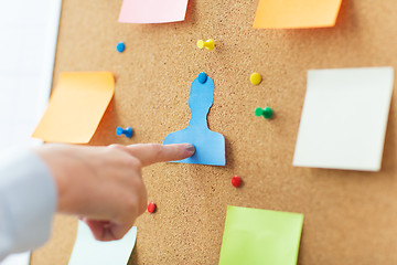 Image showing hand pointing to human shape on cork board