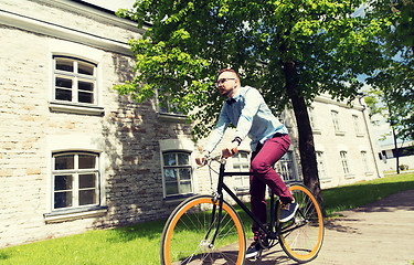 Image showing happy young hipster man riding fixed gear bike