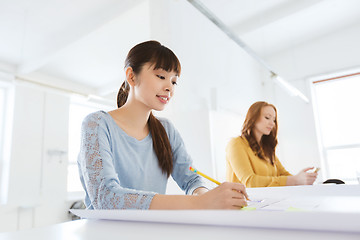 Image showing architect woman with blueprint writing at office