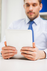 Image showing close up of businessman with tablet pc in office