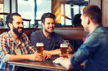 Image showing happy male friends drinking beer at bar or pub