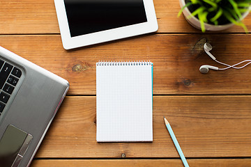 Image showing close up of notebook, laptop and tablet pc on wood