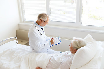 Image showing senior woman and doctor with clipboard at hospital