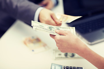 Image showing close up of hands giving or exchanging money