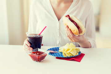 Image showing close up of woman eating hot dog with cola