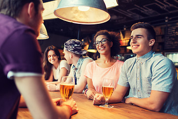 Image showing happy friends drinking beer and talking at bar