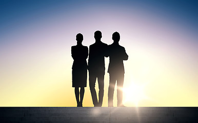 Image showing business people silhouettes on stairs over sun