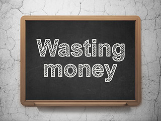 Image showing Money concept: Wasting Money on chalkboard background