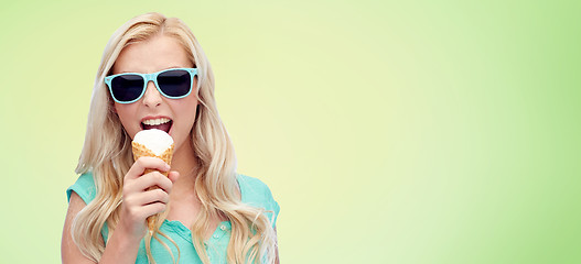 Image showing happy young woman in sunglasses eating ice cream