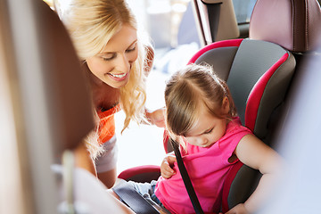 Image showing happy mother fastening child with car seat belt