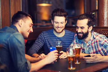 Image showing male friends with smartphones drinking beer at bar