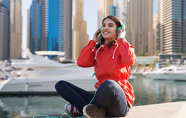 Image showing happy young woman in headphones listening to music