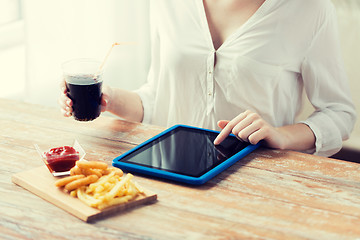 Image showing close up of woman with tablet pc and fast food