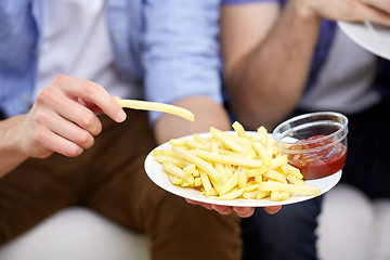 Image showing close up of man with french fries and ketchup