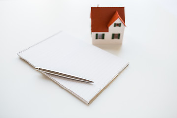 Image showing close up of house model, notebook and pencil