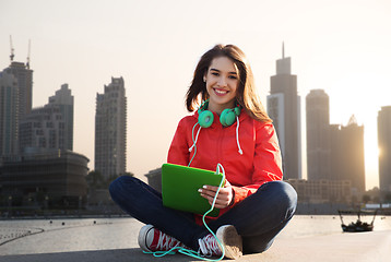 Image showing happy young woman with tablet pc and headphones