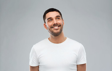 Image showing smiling man looking up over gray background