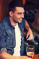 Image showing happy man drinking beer at bar or pub